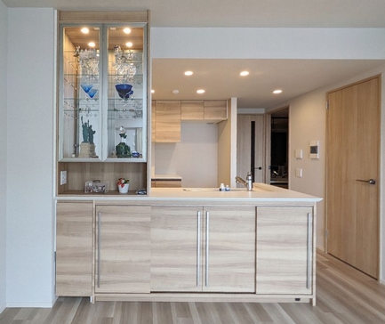 スライド引き戸のリビングカウンター下収納 ガラスディスプレイミラー照明付き